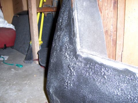 1991 Ford Bronco - Close-up view of a black textured vehicle part, possibly a bumper or fender, showing a rough, uneven surface.
