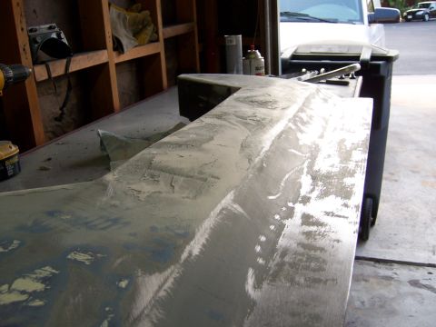 1991 Ford Bronco - A car body panel is being prepped for paint in a garage setting.