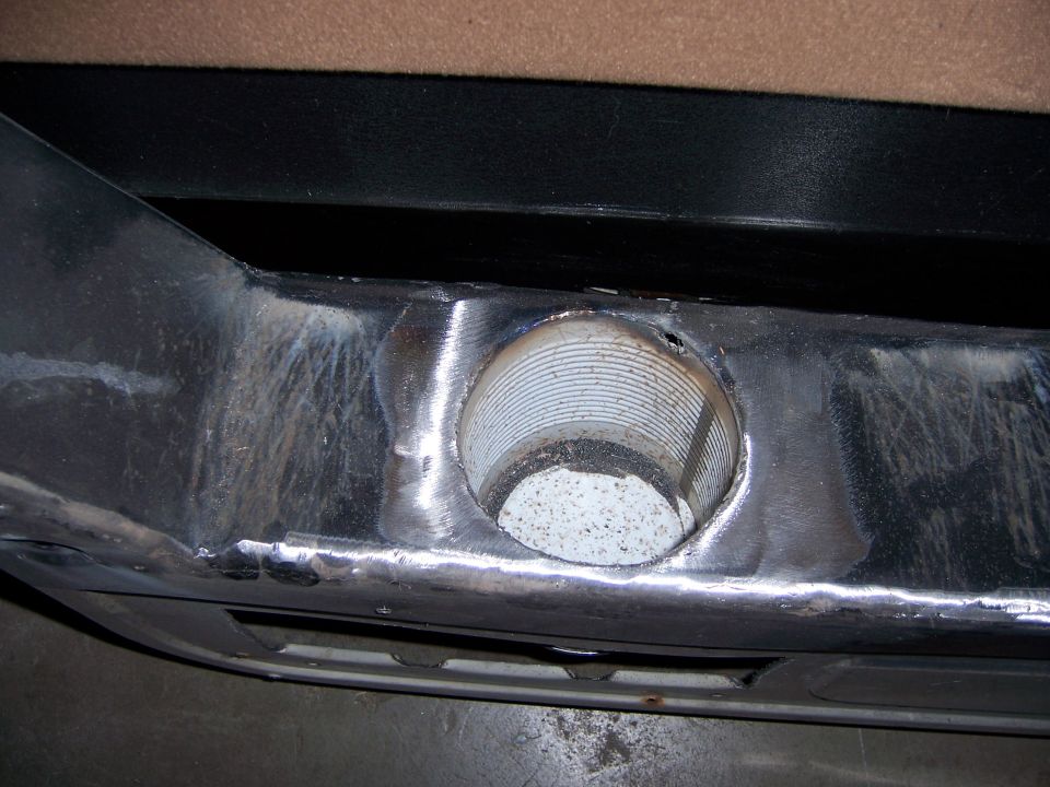 Metal bumper section with a circular opening showing ribbed interior and speckled material