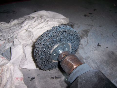 1991 Ford Bronco - A wire wheel attachment is mounted on a drill, ready for use. Paper towels are nearby.