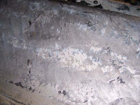 1991 Ford Bronco - This image shows a close-up of a worn metal panel with visible scratches and peeling paint, suggesting it is a part of a vehicle undergoing…
