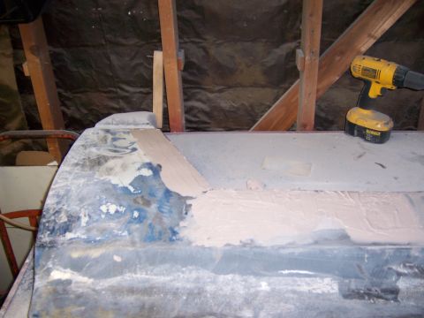1991 Ford Bronco - A vehicle body panel is undergoing repair work, with filler applied and a power drill visible in the background.