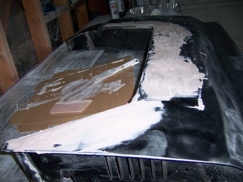 1991 Ford Bronco - Body filler is applied to a car hood, indicating repair or modification work.