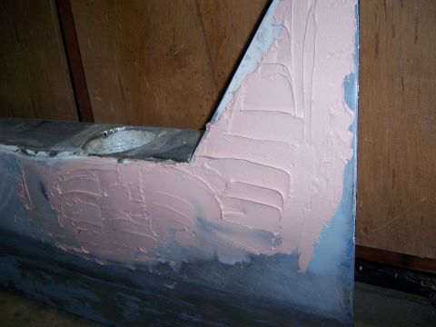 1991 Ford Bronco - Body filler is applied to a section of a car door, likely for repair or modification.