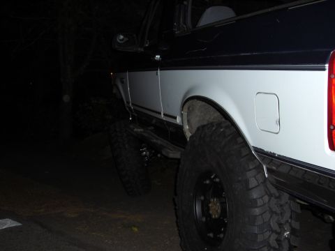 1993 Ford Bronco - This 1993 Ford Bronco features a two-tone paint scheme and aggressive off-road tires, suggesting modifications for terrain.