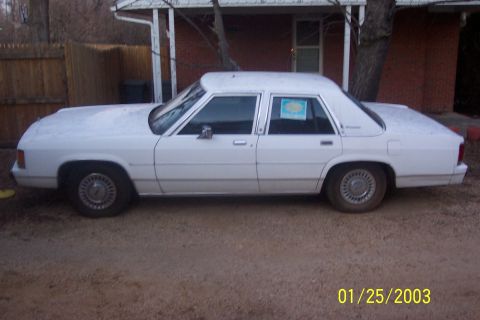 1991 Ford Crown Victoria LTD - This white sedan's body style suggests a model year in the 1980s, not 1991.