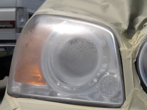 1993 Ford C-350 (Centurion Conversions) - Headlight assembly taped off for repair, with a hazy lens and another headlight visible.