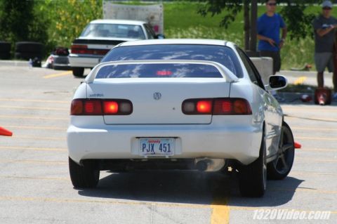 1994 Acura Integra - A white 1994 Acura Integra is parked on asphalt, with another car visible in the background.