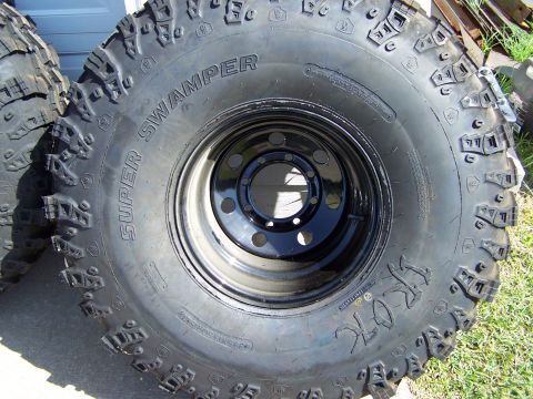 1995 Ford Bronco - A set of aggressive off-road tires, labeled 'Super Swamper', are shown mounted on black rims.