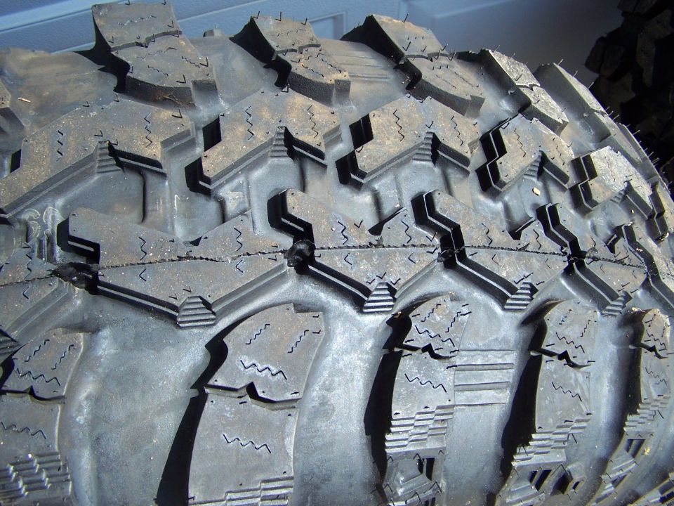 Close-up of aggressive off-road tire tread pattern with deep lugs