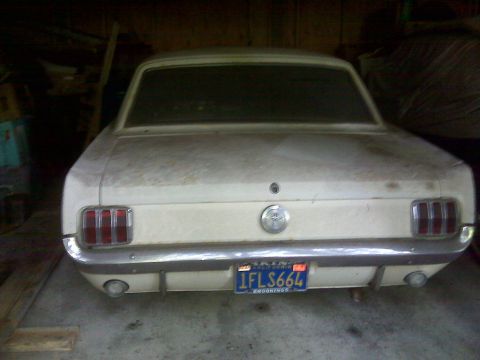 1966 Ford Mustang - Rear view of a dusty 1966 Ford Mustang coupe parked indoors.