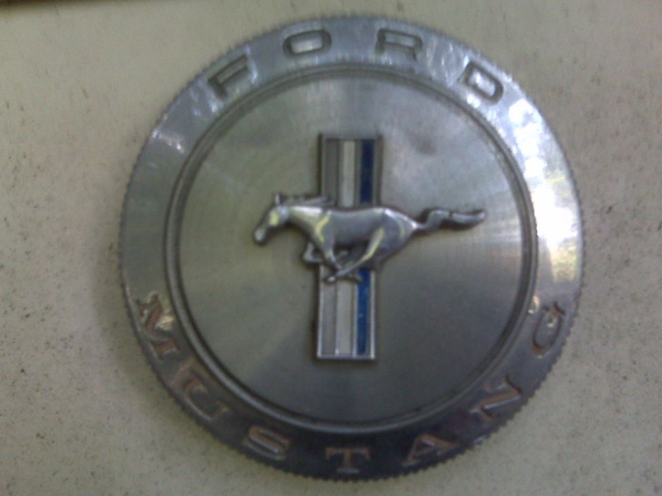 Circular chrome Ford Mustang emblem with running horse and blue stripes