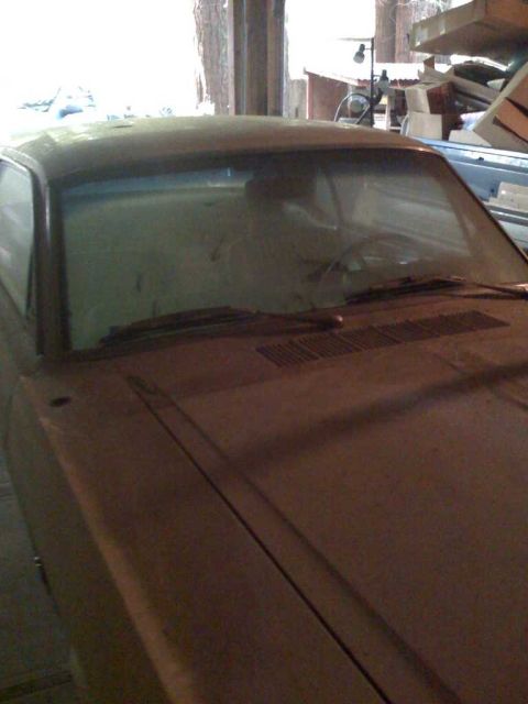 1966 Ford Mustang - The interior of a 1966 Ford Mustang shows a dusty dashboard and windshield, hinting at its current state.