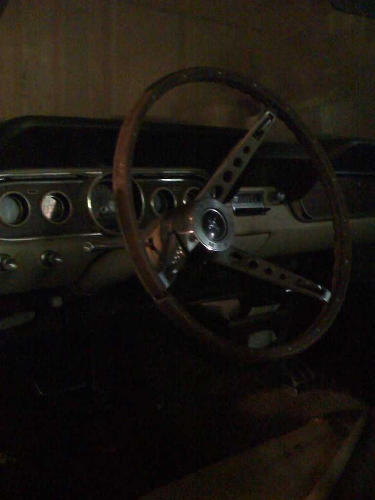 1966 Ford Mustang interior with wood-rimmed steering wheel and dashboard gauges