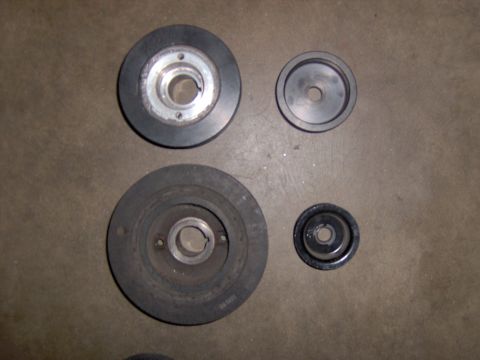 1991 Ford Taurus - Set of four automotive pulleys, likely for engine accessory drive systems.
