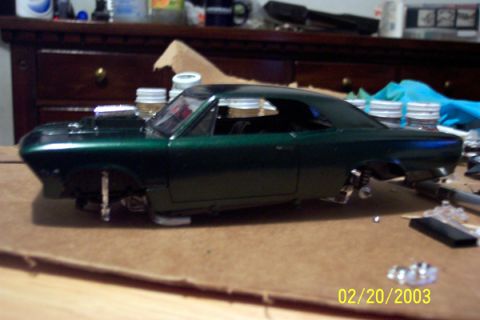 1991 Ford Crown Victoria LTD - A partially assembled model car sits on a workbench, awaiting completion.