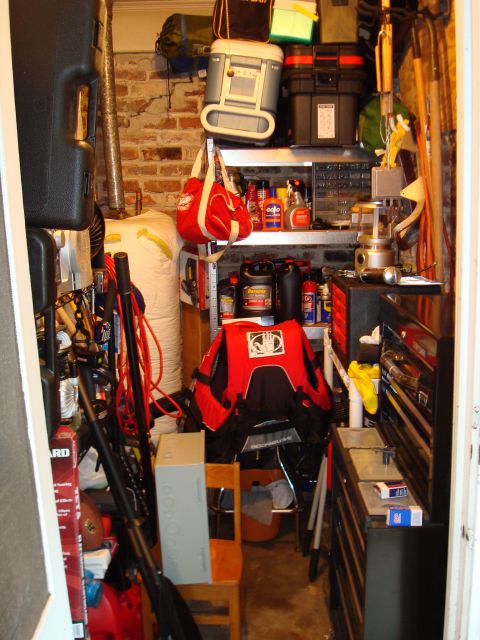 1977 Ford F-100 - A cluttered storage space filled with tools, containers, and miscellaneous items.