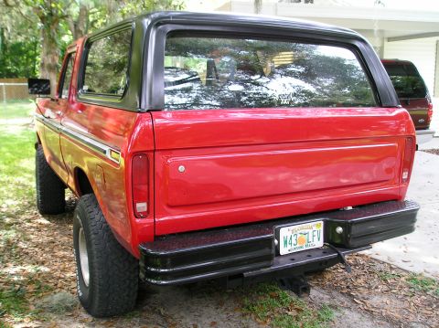 1978 Ford Bronco - Rear view of a red SUV with a black top and bumper, showing its license plate.