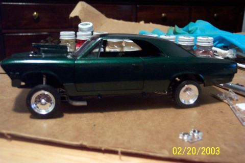 1991 Ford Crown Victoria LTD - A model car with a custom hood scoop and chrome wheels sits on a workbench next to craft supplies.