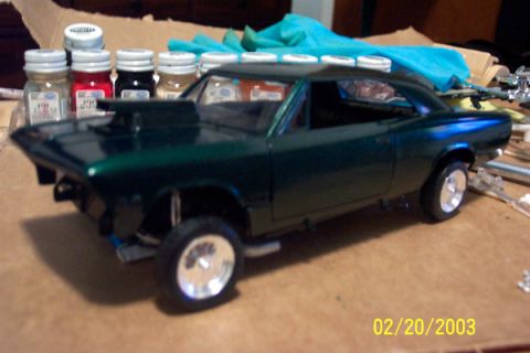 1991 Ford Crown Victoria LTD - Model car with a hood scoop and chrome wheels sits on a table with paint bottles.
