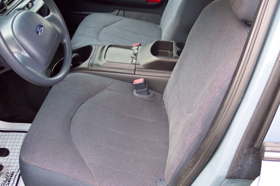 Interior of a Ford Crown Victoria showing the driver's seat, center console, and steering wheel.