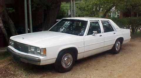 1991 Ford Crown Victoria LTD - A white 1991 Ford Crown Victoria LTD sedan is shown from the front three-quarter angle.