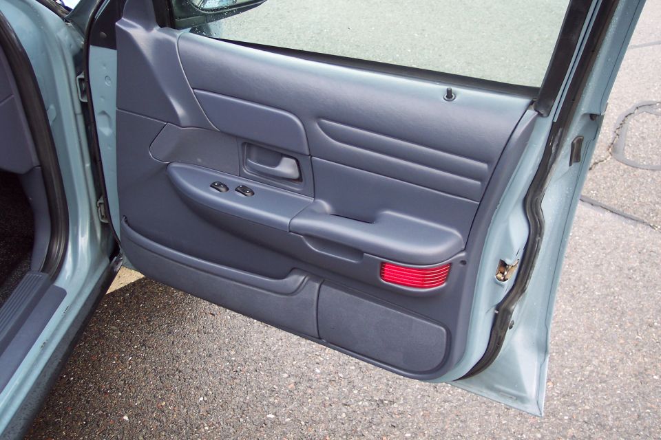 Interior driver's side door panel of a light blue sedan.