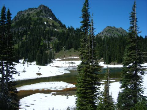 2005 Jeep Wrangler - A scenic mountain landscape with snow-covered ground and a lake, surrounded by evergreen trees under a clear blue sky.