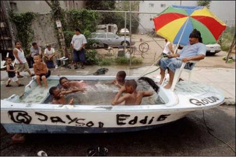 1991 Ford Crown Victoria LTD - A group of people are enjoying a makeshift pool inside a boat, with names painted on the hull.
