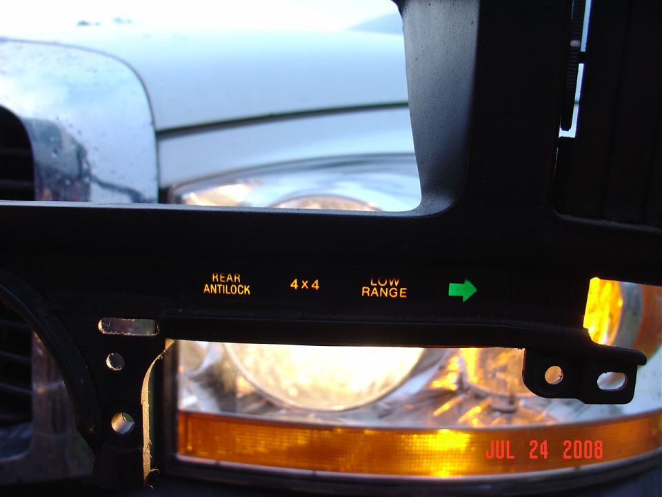 Lit dash indicators: REAR ANTILOCK, 4x4, LOW RANGE and green arrow, seen through disassembled dash panel