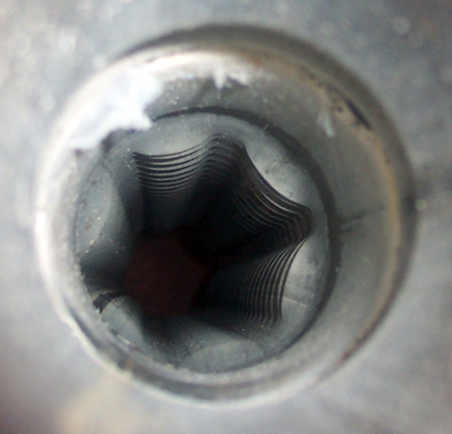 Close-up of a Torx star-shaped recess in a metal fastener or socket bore