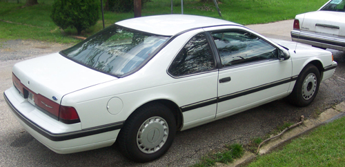 White Ford Thunderbird coupe rear three-quarter view on gravel driveway