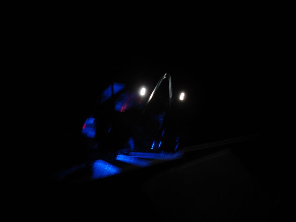 Blurry side view of a vehicle with blue and red lights reflecting.