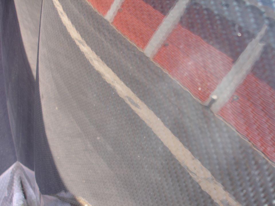 Close-up of dark gray textured fabric with a light stripe and red/white striped material.