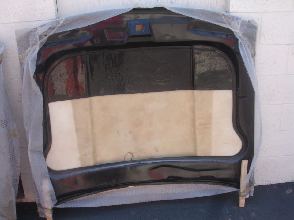 Underside of a black car hood with protective wrapping