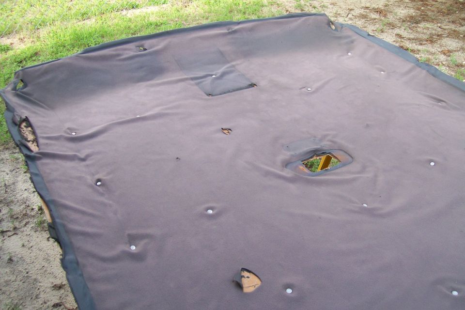 Detached vehicle headliner with holes and clips on the ground