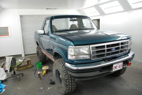 1996 Ford Bronco - Photograph of a teal lifted Ford pickup parked in a garage, not a technical document.