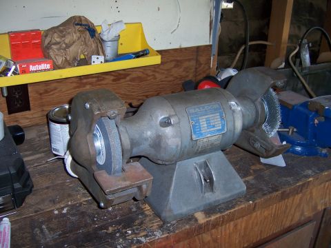 1991 Ford Bronco - Photograph of a bench grinder on a workbench, not a technical document.