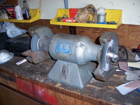 1991 Ford Bronco - Photograph of a bench grinder on a workbench, not a technical document.