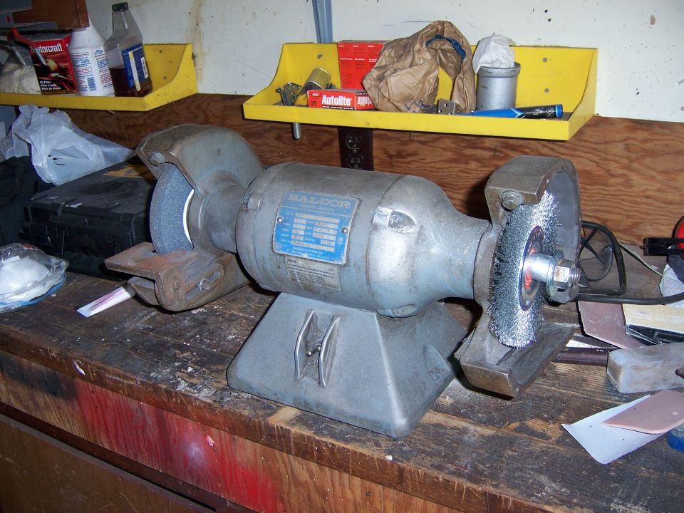 Bench grinder with wire wheel on a garage workbench