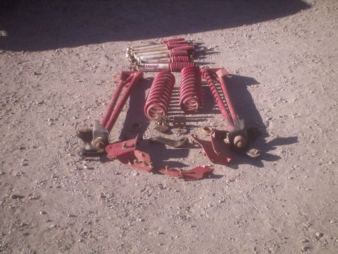 1991 Ford Bronco - Collection of suspension parts and Rancho shocks displayed on a gravel surface.