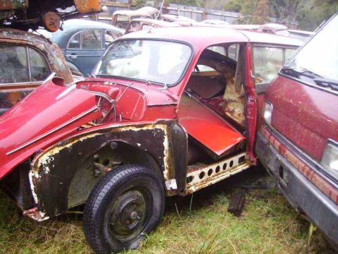 1969 MINI Cooper - A red car with its doors and hood open, revealing its interior and engine compartment.
