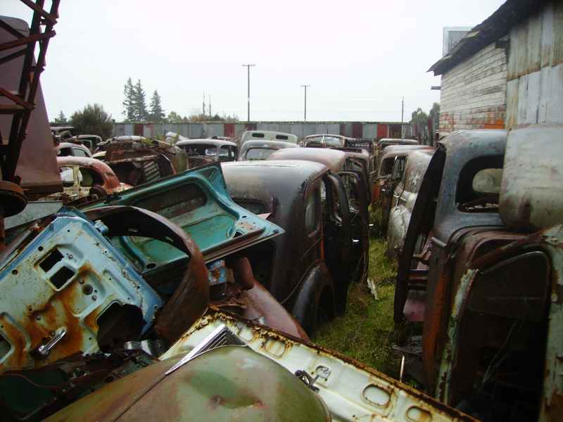 Junkyard scene with many rusty old cars and car parts