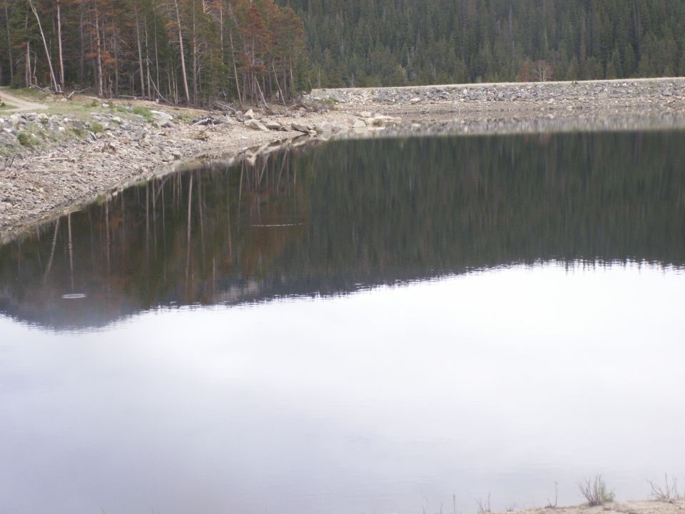 Lake reflecting trees and rocky shore