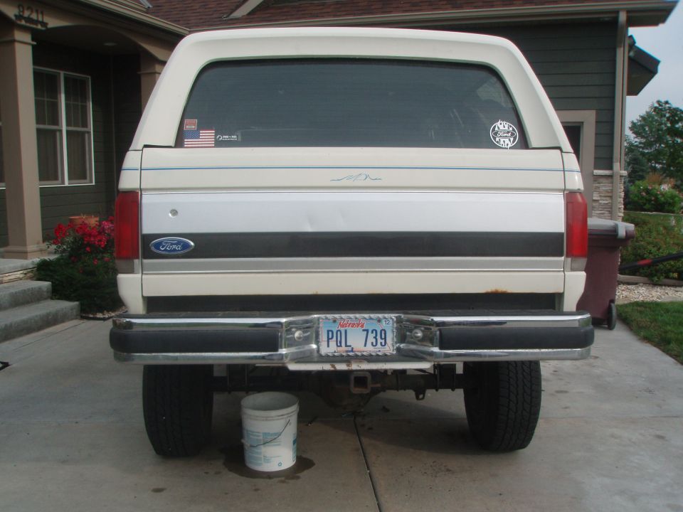 Rear view of a white Ford Bronco with a camper shell and Nebraska license plate.