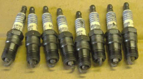 2007 Ford Mustang - Photograph of eight removed Motorcraft platinum spark plugs lined up on cardboard.