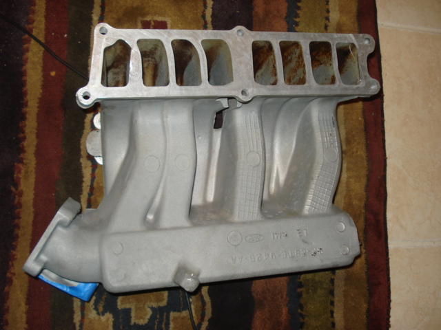 Aluminum intake manifold resting on a patterned rug