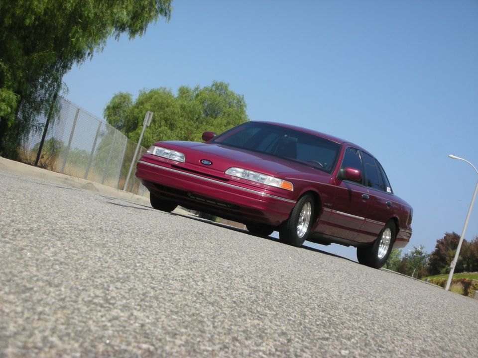 Maroon 1992 Ford Crown Victoria sedan parked on a road.