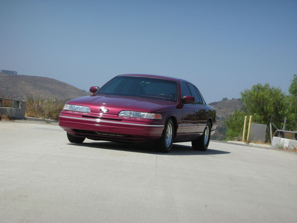 Maroon 1990s Ford Crown Victoria sedan parked outdoors.