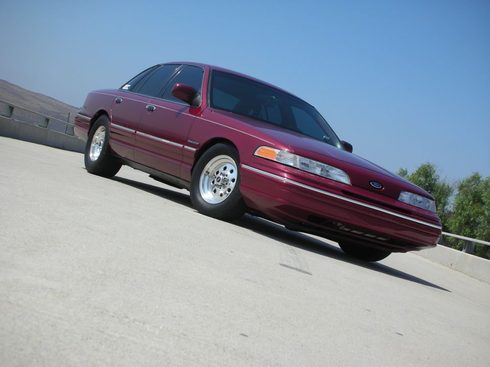 Maroon 1992 Ford Crown Victoria parked on concrete, low angle front quarter view.